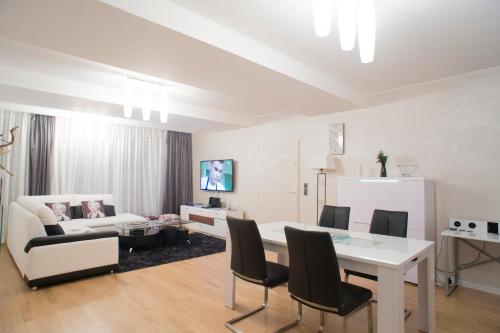 a living room with a table and a couch at The Queen Luxury Apartments - Villa Marilyn in Luxembourg