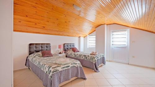 UzumluにあるVilla Xclusiveの木製天井のドミトリールームのベッド2台分です。
