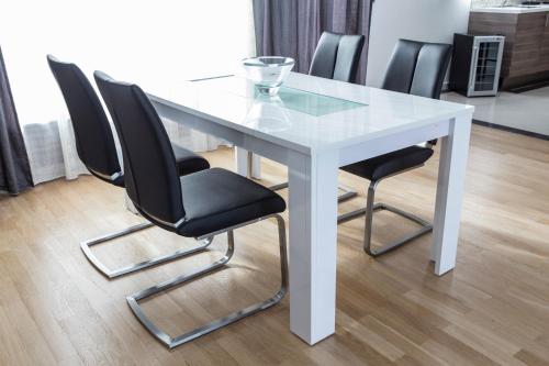 a white table with four black chairs around it at The Queen Luxury Apartments - Villa Marilyn in Luxembourg