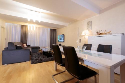 a kitchen and living room with a table and chairs at The Queen Luxury Apartments - Villa Marilyn in Luxembourg