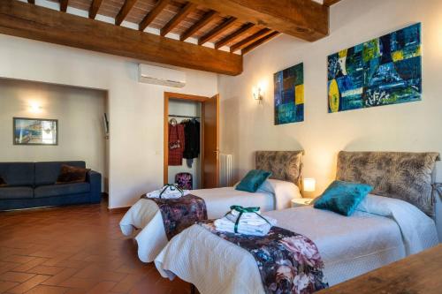 a living room with two beds and a couch at La Dimora nell'Anfiteatro Superior room and apartment Self check in Elevator Air Conditioning in Lucca