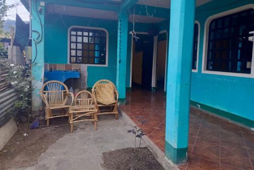 ein blaues Haus mit 3 Stühlen und einem Tisch in der Unterkunft Casa Xuan in San Juan La Laguna