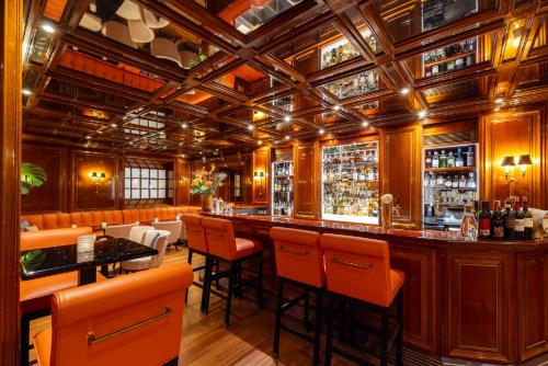a bar in a restaurant with orange bar stools at Excelsior Hotel Ernst am Dom in Cologne