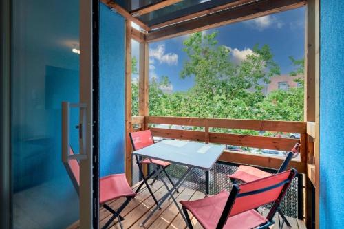 un patio avec une table et des chaises sur un balcon dans l'établissement Le SCANDINAVE Centre Ville/2 chambres + Terrasse, à Colmar