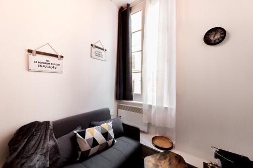 un salon avec un canapé et une fenêtre dans l'établissement Duplex dans les pentes de la Croix-Rousse AIL, à Lyon
