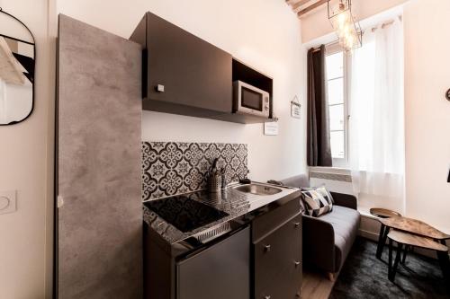 une petite cuisine avec un évier et une cuisinière dans l'établissement Duplex dans les pentes de la Croix-Rousse AIL, à Lyon