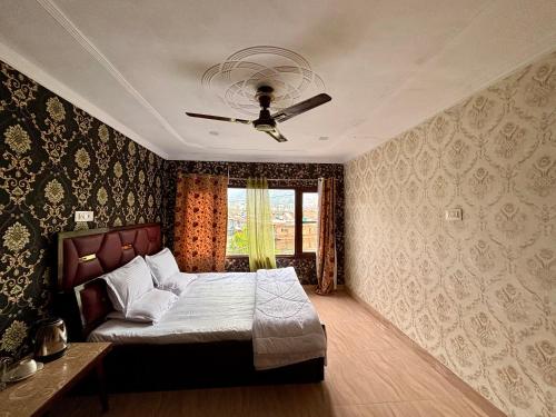 a bedroom with a bed and a ceiling fan at Hotel Crescent in Srinagar