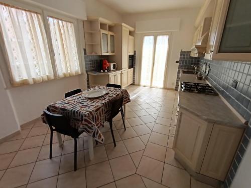 uma cozinha com uma mesa e cadeiras numa cozinha em A casa di Berna e Tere em Venturina Terme