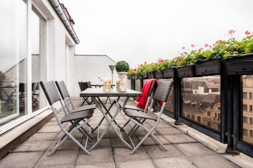 a table and chairs on a balcony at The Queen Luxury Apartments - Villa Marilyn in Luxembourg