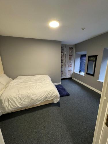 1 dormitorio con cama blanca y pared en Habibi House en Longford