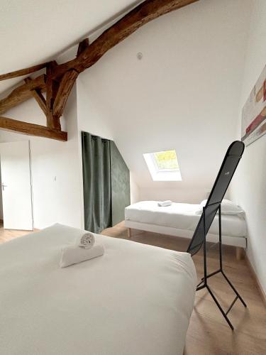 a bedroom with two beds and a chair in it at L'Escapade Nature et SPA, 10 mn du ZooParc de Beauval in Saint-Romain-sur-Cher