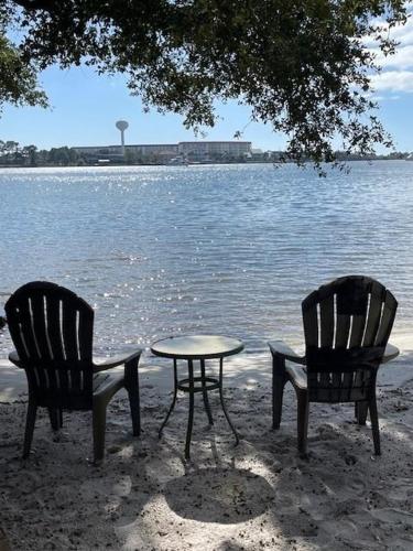 two chairs and a table in front of a lake at PB B204 - Close to Beach - Optional Boat Slip in Fort Walton Beach