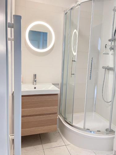une salle de bain avec une douche, un lavabo et un miroir dans l'établissement CABOURG - 2 PIÈCES avec Balcon et parking- Hyper Centre et Plage, à Cabourg