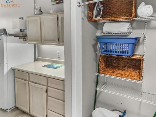 a kitchen with white cabinets and blue baskets at PB B204 - Close to Beach - Optional Boat Slip in Fort Walton Beach