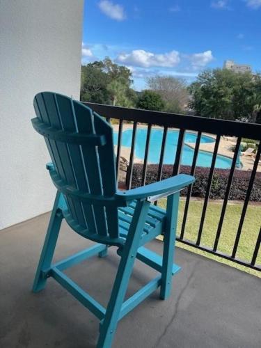 a blue chair sitting on a balcony overlooking the ocean at PB B204 - Close to Beach - Optional Boat Slip in Fort Walton Beach