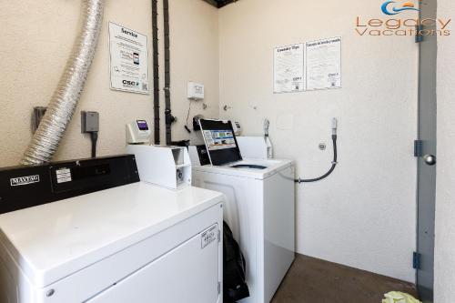 a laundry room with a washing machine and a phone at PB B204 - Close to Beach - Optional Boat Slip in Fort Walton Beach