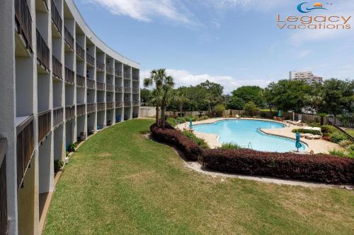 an exterior view of a building with a swimming pool at PB B204 - Close to Beach - Optional Boat Slip in Fort Walton Beach