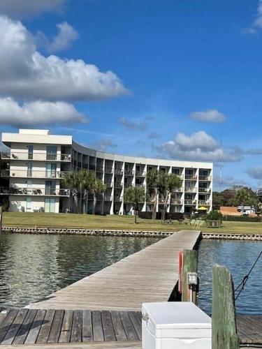 a building next to a body of water with a dock at PB B204 - Close to Beach - Optional Boat Slip in Fort Walton Beach