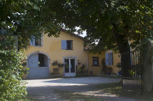 una casa amarilla con puerta y entrada en Alaudy Vacances Séjours écologiques - 3 gites, en Ossages