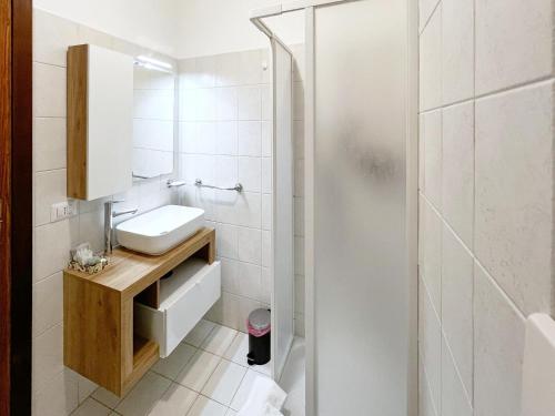 a white bathroom with a sink and a shower at Il Tiglio in Montemonaco