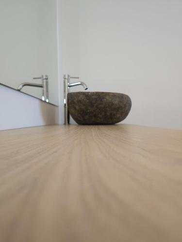 a stone bowl sitting on a wooden floor in a room at Boomerang Sea View Accommodation and Studios in Plános