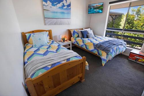 2 camas en una habitación con ventana en Livin the Dream, en Lakes Entrance