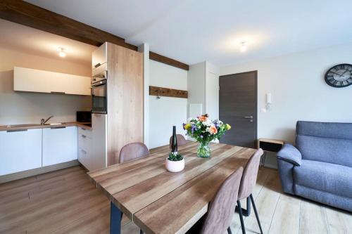 une cuisine et une salle à manger avec une table et un canapé bleu dans l'établissement L'ALSACIEN Centre Ville 2 chambres et Terrasse, à Colmar