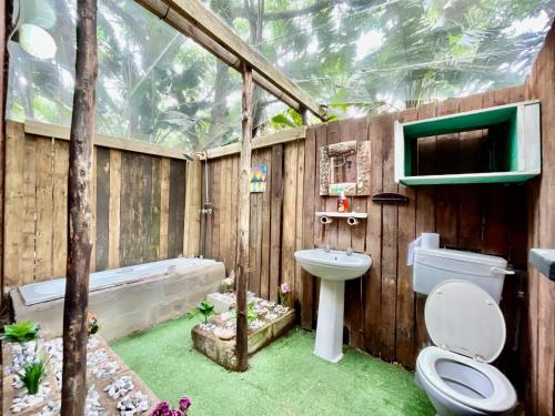 a bathroom with a toilet and a bath tub at Mantis and Moon Backpackers and Surf Hostel in Hibberdene