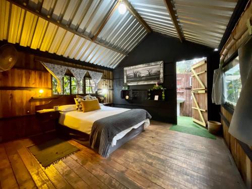 una camera con un grande letto in una casa di Mantis and Moon Backpackers and Surf Hostel a Hibberdene