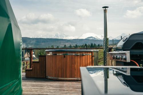 a view of mountains from a deck with a building at Góralski Harem Osada Glamp Jacuzzi & Balia in Zakopane