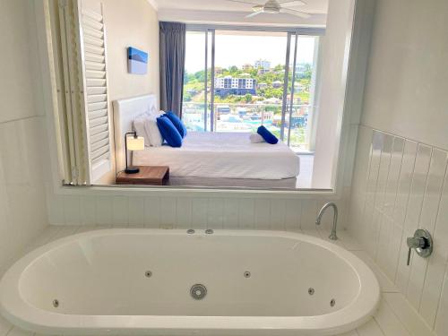a bath tub in a room with a bed at Apartment 1102 | 11th Floor River & Stadium Views in Townsville