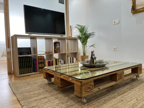 a living room with a coffee table and a flat screen tv at Apartamento Salsipuedes-La Catedral in Oviedo