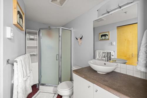 een badkamer met een glazen douche en een wastafel bij Funky & Fun 1 Bedroom Condo Downtown Victoria, Free Parking! in Victoria