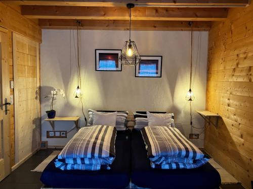 a bedroom with two beds and a chandelier at Chalet Alpina Gyger in Wengen