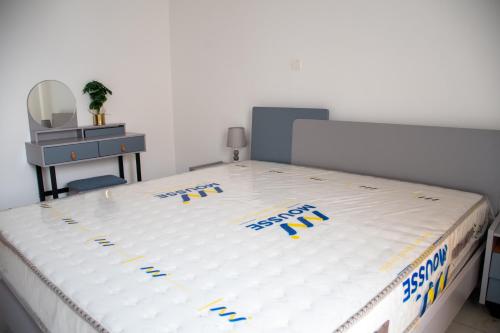 a bed with a white mattress with blue writing on it at Appartement MONGOH in Nzamata