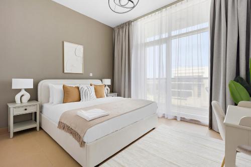 1 dormitorio con cama blanca y ventana grande en Silkhaus Contemporary 1 BDR Next to Golf Course, en Abu Dabi