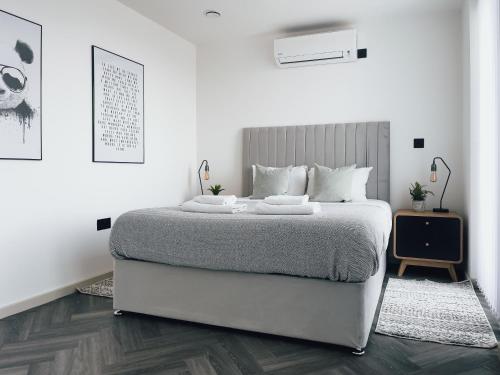 a white bedroom with a large bed in it at Luxe Penthouse Retreat: With Free Parking! in Brentford