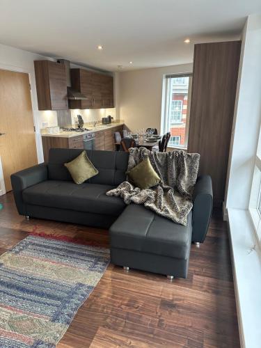 a living room with a couch and a kitchen at Modern & spacious 3 bed with free parking & lift in Shoreditch, next to station in London
