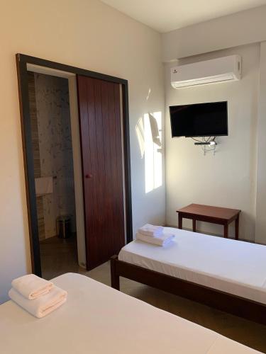 a hotel room with two beds and a television at Hotel Il Castello in Villa Concepción