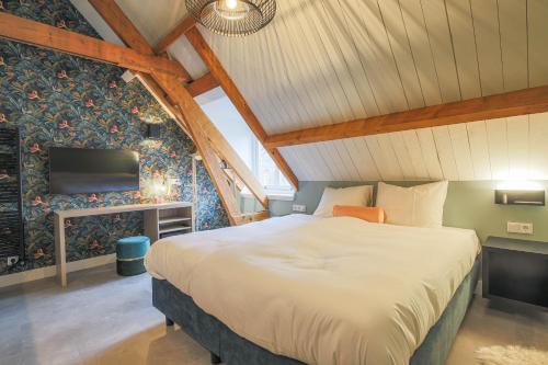 a bedroom with a large bed in a attic at Hotel Zoet & Slaap in Biggekerke