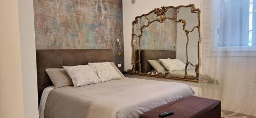 - une chambre avec un lit et un miroir mural dans l'établissement Dimora del Castello - Comfort & Privacy, à Castel Maggiore