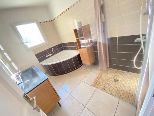 une grande salle de bain avec une baignoire et un lavabo dans l'établissement Villa piscine. Plage à 20 min lac à 5min, à Roquebrune-sur Argens