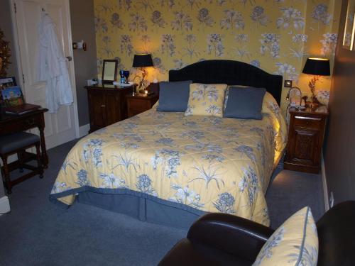 a bedroom with a bed with a blue and white comforter at Beechwood Hotel in North Walsham