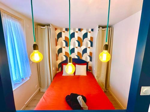 - une petite chambre avec un lit rouge et deux lumières dans l'établissement La vacancière - 308, à Rouen