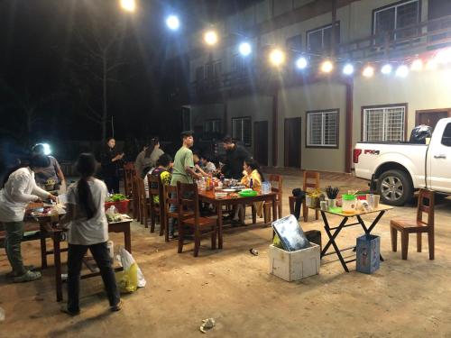 a group of people standing around tables with food at Samnang Leap guesthouse in Senmonorom