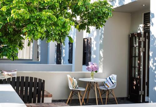 a table with two chairs and a vase of flowers at Apartment in central Stellenbosch in Stellenbosch