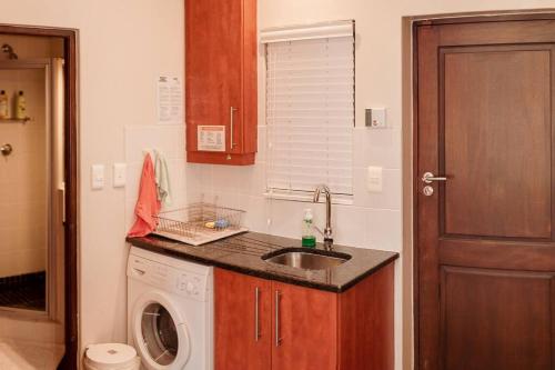 a kitchen with a sink and a washing machine at Apartment in central Stellenbosch in Stellenbosch