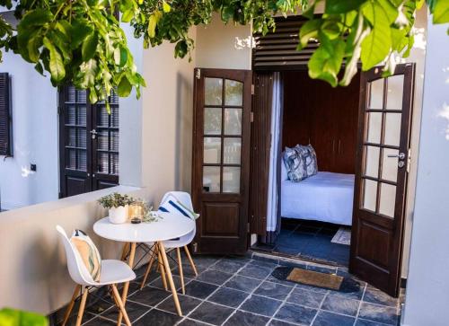 Cette chambre comprend une table, des chaises et un lit. dans l'établissement Apartment in central Stellenbosch, à Stellenbosch