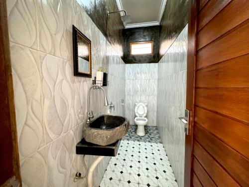 uma casa de banho com um lavatório e um WC em Asri Dana Guest House em Ubud