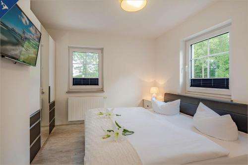 um quarto com uma grande cama branca com flores em Villa Doris Whg 3 Flora em Heringsdorf